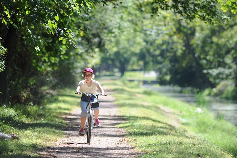 File:Woman rides her bike along the Delaware Canal in Tinicum State Park. The state Department of Conservation and Natural Resources say proposed budget cuts could repairs to the Delaware Canal system.