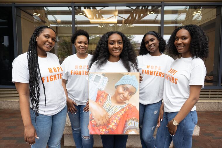 (from left) Sisters Joy Wells, Glory Wells, Charity Wells, Grace Wells, and Faith Wells shown here outside Hospital of the University of Pennsylvania holding a photo of their sister Hope Wells, who has been battling cancer for two years.