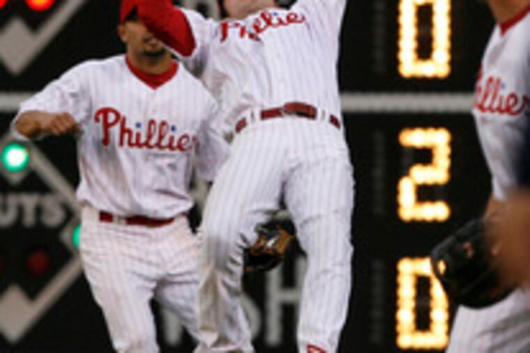 Chase Utley makes the adjustment - and the catch - on a wind-carried fly by Bill Hall in the third inning at Citizens Bank Park. Shane Victorino, who had misplayed a fly earlier, closed in from right field.
