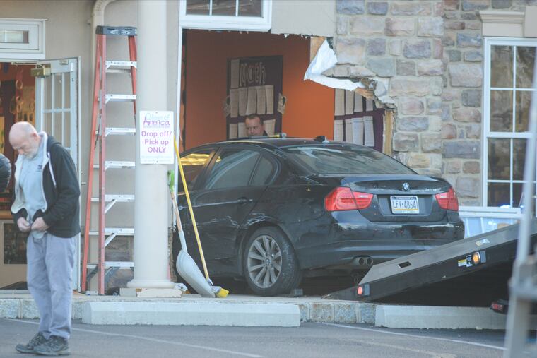 Police personnel remove the vehicle after a woman crashed it into the day care, injuring four children, one seriously.