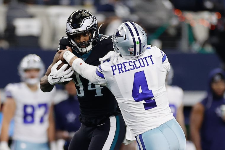 Eagles defensive end Josh Sweat shoves off Dallas Cowboys quarterback Dak Prescott after a Sweat interception in the first quarter on Saturday, December 24, 2022 at AT&T Stadium in Arlington, TX. Sweat scored a touchdown o n the play.