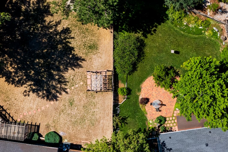 A home with a brown lawn sits next to a home with a green one on July 24, in Denver.