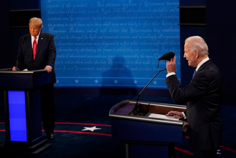 Democratic presidential candidate former Vice President Joe Biden holds up a mask as President Donald Trump takes notes during the second and final presidential debate Thursday, Oct. 22, 2020, at Belmont University in Nashville, Tenn.