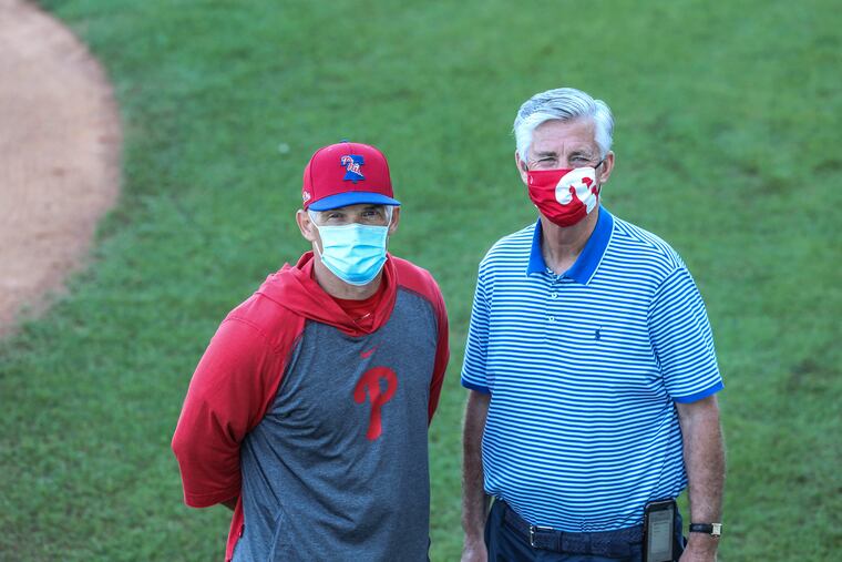 Phillies manager Joe Girardi, left, and president of baseball operations Dave Dombrowski chatting on the field before a spring-training game March 5 in Clearwater, Fla.