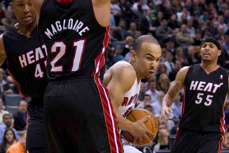 Jerry Bayless of the Toronto Raptors drives through Miami Heat players (from left to right) Dexter Pittman, Jamaal Magloire, and Eddie House during Wednesday night's game.