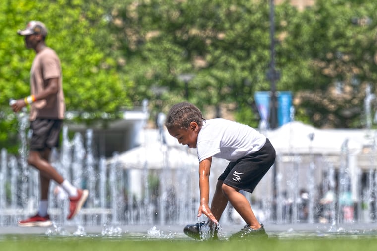 Dajé Jones, 3, cools off in the water fountains at Dilworth Park outside City Hall on Monday, the first of two days of record heat in Philly.