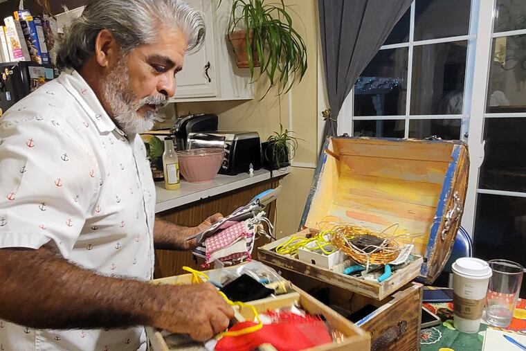 Rogelio Zavala busca en la caja de materiales recuperados que utiliza para crear su arte. Hace 37 años, Zavala se mudó de México a Avondale, Pensilvania y luego a Wilmington, Delaware donde él y todas sus hijas crean artesanías y arte.