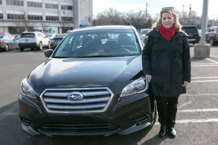 Sheri Minkoff stands next to her repaired Subaru Legacy that had been damaged in a hit-and-run accident. She had waited two hours for 911 to send someone to her rescue.