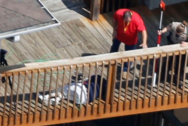 STEVE HELBER / ASSOCIATED PRESS Investigators look over the body of cameraman Adam Ward after he and reporter Alison Parker were fatally shot.