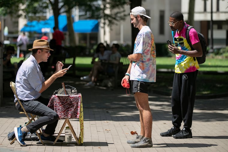 "Dream Poet for Hire" Marshall James Kavanaugh reads a poem he wrote for Dave Schimpf, 22, while Al Black, 47, listens behind him in Rittenhouse Square.