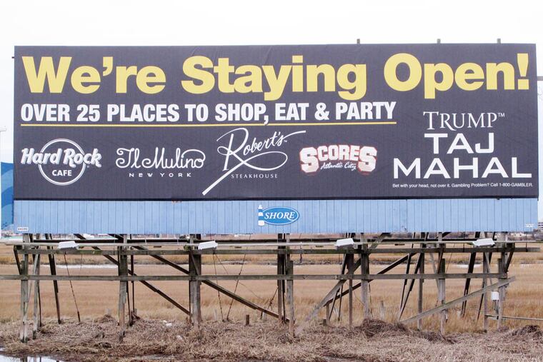 This Dec. 29, 2014 photo shows a billboard in Atlantic City, N.J. letting customers know the Trump Taj Mahal casino will remain open during 2015. Its owners, Trump Entertainment Resorts, have begun a promotional campaign to let customers who have seen months of news coverage of the casino's threatened closure know that it will continue to operate.(AP Photo/Wayne Parry)