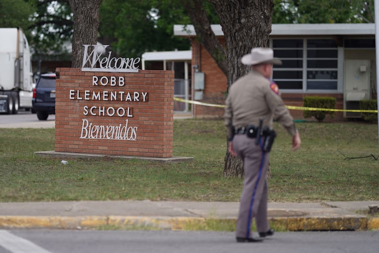 An officer walks outside of Robb Elementary School in Uvalde, Texas, on Tuesday.