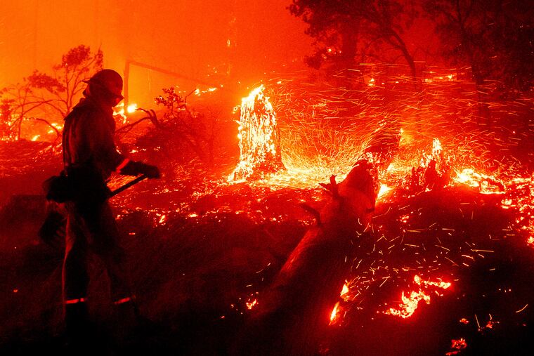 Embers fly from a tree stump as the Creek Fire burns in the Cascadel Woods neighborhood of Madera County, Calif., on Monday.