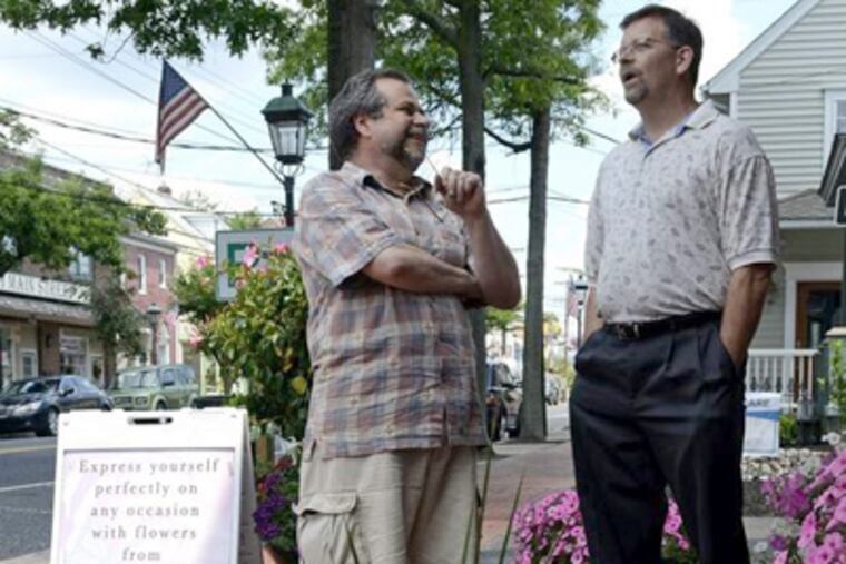 Medford Mayor Randy Pace (right) talks with Simon Iredale, who owns Medford Florist & Gift Shop, as he walks along Main Street. TOM GRALISH / Staff Photographer