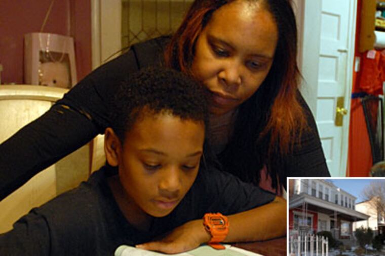 Donita Bagner helps her adopted son Bryan Drummond with his homework in her home. (Ron Tarver / Staff Photographer)