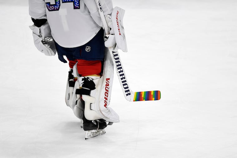 Florida Panthers goaltender Alex Lyon (34) warms up while celebrating Pride Night with a colorful hockey stick before a game in March.
