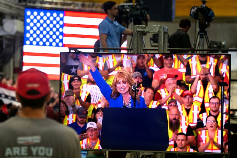 State Treasurer and Republican candidate for governor Stacy Garrity is seen on a big screen as she speaks to supporters before the arrival of President Donald Trump at Mack Trucks in Macungie Tuesday, June 23, 2026.