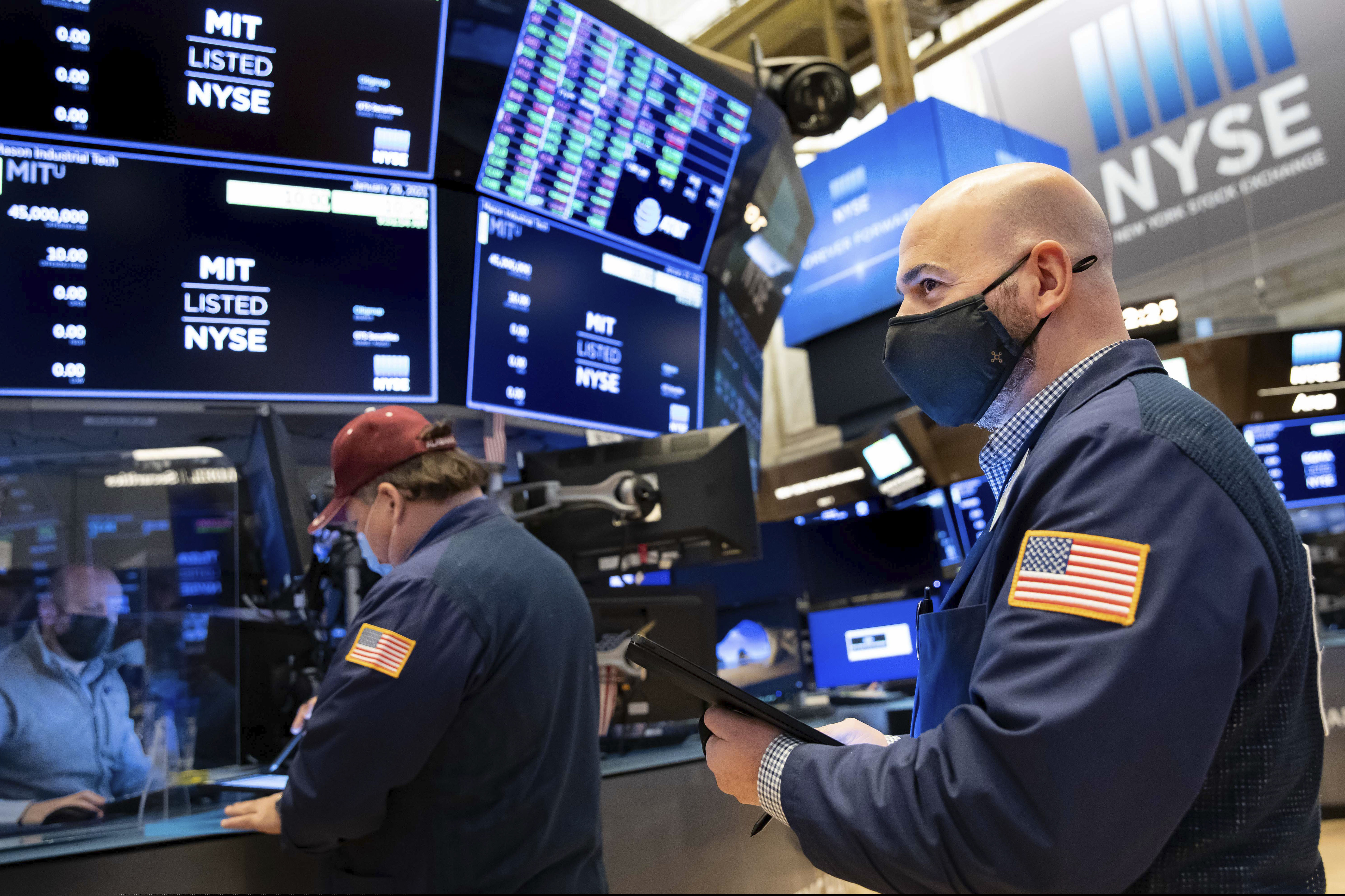 On Friday at the New York Stock Exchange, trader Fred Demarco, right, works on the floor. After falling back Thursday, GameStop's stock climbed again on Friday.