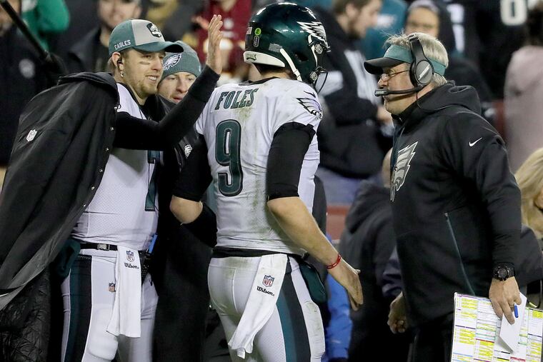 Eagles quarterback Nick Foles, center, is celebrates after his touchdown pass with Eagles quarterback Nate Sudfeld, left, Eagles quarterback Carson Wentz, and Eagles head coach Doug Pederson, right, in the 2nd quarter against Washington. The Philadelphia Eagles play the Washington Redskins at FedExField in Landover, MD on December 30, 2018.