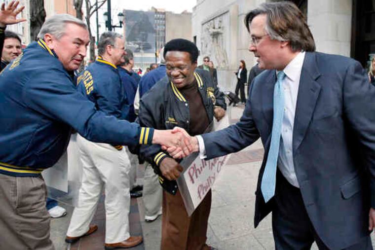 Union employees of Philadelphia Newspapers, above, greet publisher Brian P. Tierney (right) yesterday to support his efforts to bring the newspapers out of bankruptcy. Below, Fred S. Hodara (right), attorney for the lenders, views their signs.