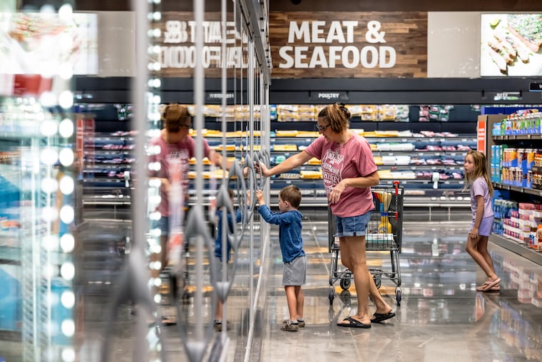 Accompanied by her children, a woman shops at an Aldi store in Westlake, Fla., in July 2025. Consumers are making fewer trips to traditional grocery stores in favor of discount chains like Aldi.