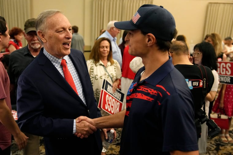 Rep. Andy Biggs (left) greets a supporter last week at a campaign event in Gilbert, Ariz.