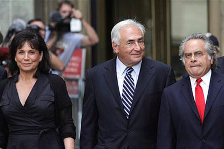 Former International Monetary Fund leader Dominique Strauss-Kahn, center, leaves Manhattan state Supreme court with his wife Anne Sinclair, left, and attorney Benjamin Brafman after a hearing Tuesday, Aug. 23, 2011 in New York. A New York judge dismissed the sexual assault case against Strauss-Kahn, but the order is on hold until an appeals court rules on his accuser's request for a special prosecutor. (AP Photo / Mary Altaffer)
