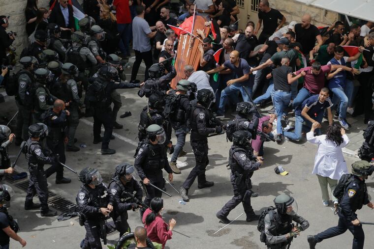 Israeli police confront with mourners as they carry the casket of slain Al Jazeera veteran journalist Shireen Abu Akleh during her funeral in east Jerusalem.