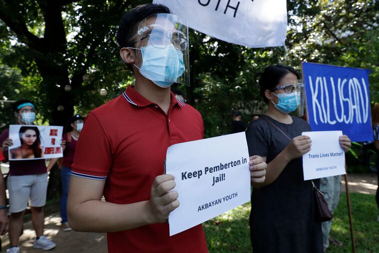 Protesters hold slogans against the release of U.S. Marine Lance Cpl. Joseph Scott Pemberton during a rally in Quezon city, Philippines on Friday, Sept. 11, 2020. The Philippine president recently pardoned Pemberton in a surprise move that will free him from imprisonment in the 2014 killing of a transgender Filipino woman that sparked anger in the former American colony.