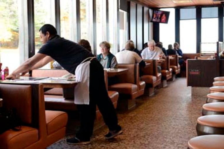 Llanerch Diner Busboy Walter Real cleans the booth occupied by Bradley Cooper and Jennifer Lawrence during filming of the new movie, "Silver Linings Playbook" in Upper Darby. TOM GRALISH / Staff Photographer