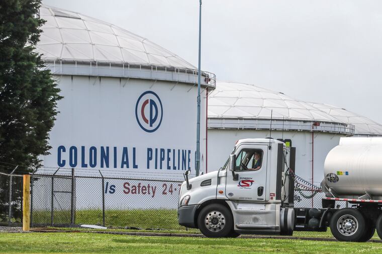 Gasoline tankers pass by the Colonial Pipeline storage tanks in Austell, Ga.