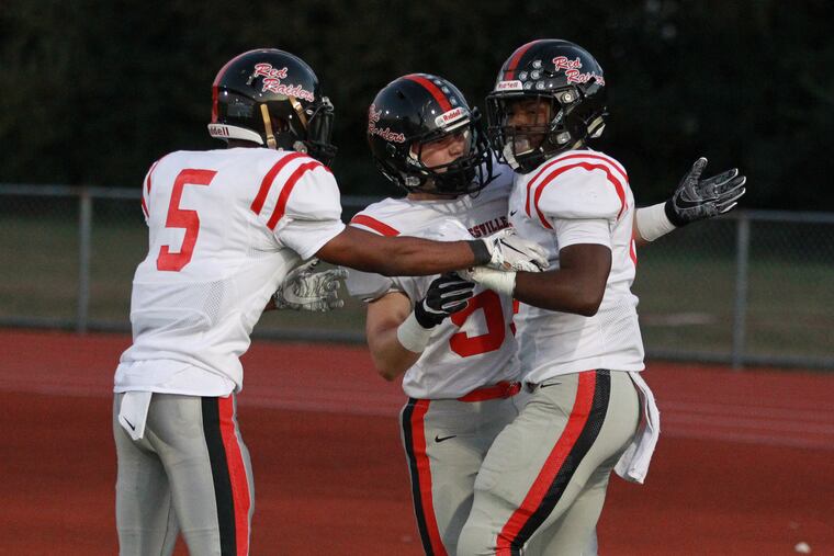 Dapree Bryant (right) of Coatesville is congratulated by Amir Kennedy (left) and Nolan O’Hara (center) after returning a punt for a touchdown against Unionville in September.