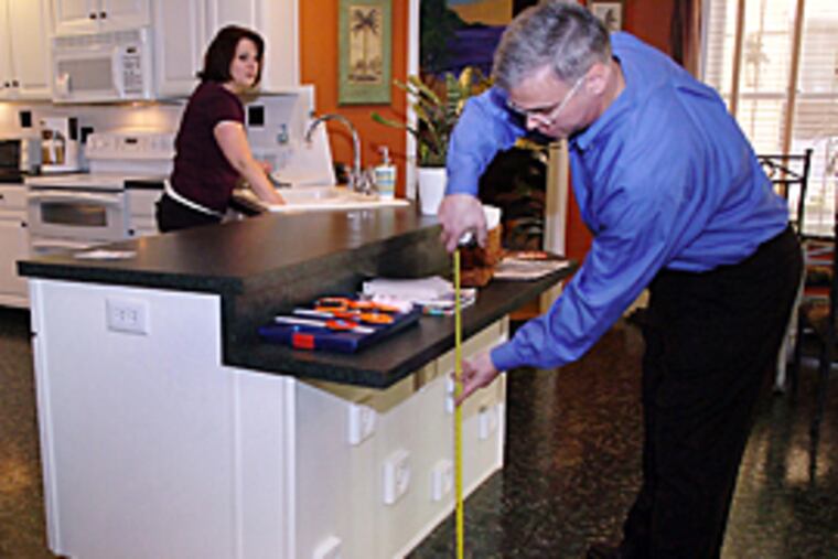 Andrew Borislow, founder of AcessAll, inspects the Lower Gwynedd home of Lisa Meade to see if it is wheelchair accessible. He is checking the height of a kitchen counter. (Sharon Gekoski-Kimmel / Inquirer)