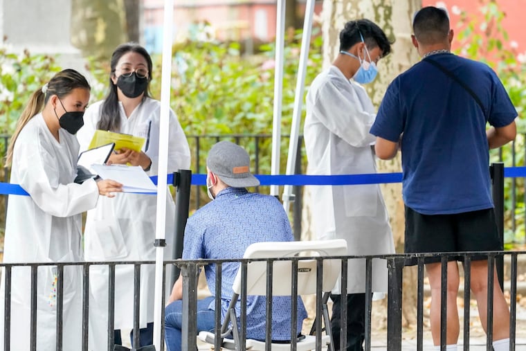 Healthcare workers with New York City Department of Health and Mental Hygiene help people register for the monkeypox vaccine at one of the City's vaccination sites on July 26 in New York.