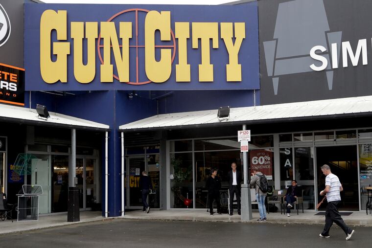 Ian Britton walks into a gun shop in Christchurch, New Zealand, Sunday, March 17, 2019. Gun ownership in New Zealand is being discussed after a mass shooting at two area mosques. (AP Photo/Mark Baker)