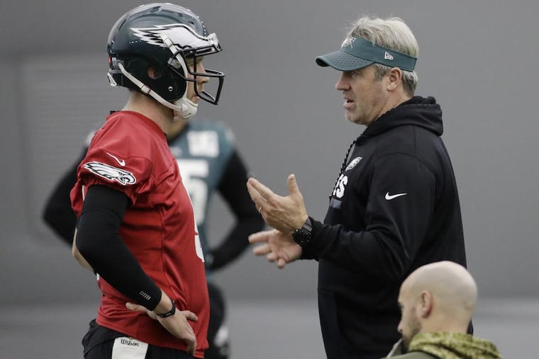 Philadelphia Eagles head coach Doug Pederson speaks with quarterback Nick Foles during practice at the team's NFL football training facility in Philadelphia, Thursday, Jan. 18, 2018. (AP Photo/Matt Rourke)
