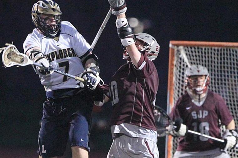 Aidan Kerrigan, left, of LaSalle leaps to catch a ball as he tries to
score in the final second of the third quarter against Ryan Neff,
center, of St. Joseph's Prep in boys' lacrosse, 7 p.m. at Plymouth
Whitemarsh on May 1, 2014. The game was delayed by lightning att
ehstart of the 4th quarter with the score tied 5-5. ( CHARLES FOX /
Staff Photographer )