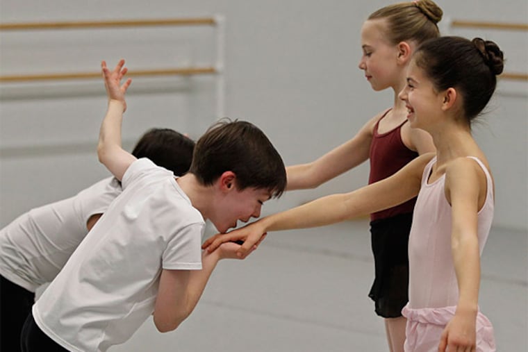 Jane Cohen, 10, center, breaks into nervous giggles after Aidan Duffy, 9, kissed her hand during rehearsals of"George Balanchine's The Nutcracker" at the School of Pennsylvania Ballet. (Michael Bryant/Staff Photographer)