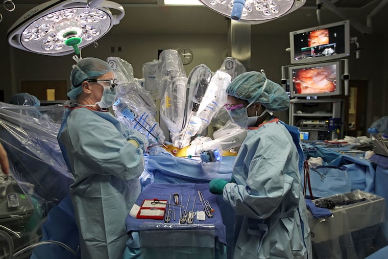 Medical staff at Temple prepare for robotic surgery. Nurses were one of 10 "opportunity occupations" identified in a Wednesday report by the Federal Reserve Banks of Philadelphia and Cleveland. ( MICHAEL BRYANT / Staff Photographer )