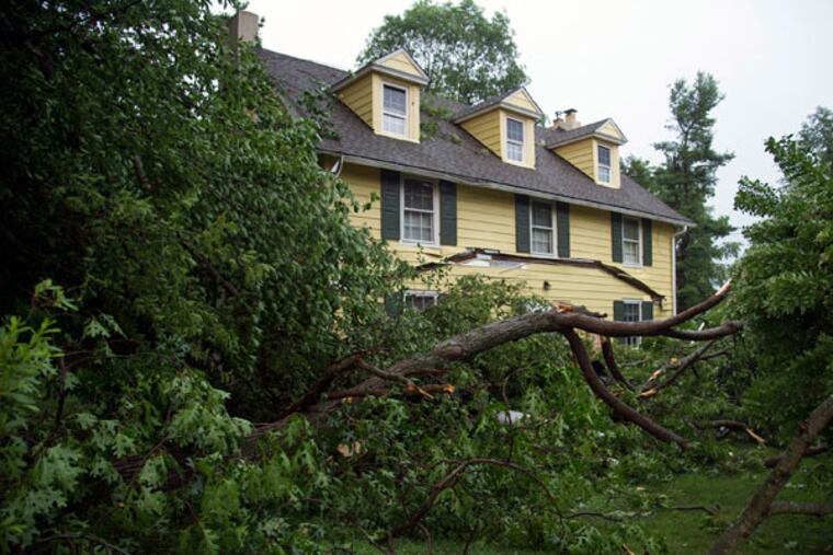 Part of a tree fell onto the front porch of a house on Westtown-Thornton Road in Thornton, collapsing the roof after a severe thunderstorm rolled through the area June 23, 2015. (CLEM MURRAY/Staff Photographer)