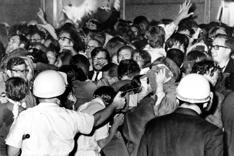 A police officer is seen squirting mace, a body-disabling chemical, at a crowd of anti-war demonstrators outside the Hilton Hotel in Chicago on August 29, 1968. Hundreds were injured in the bloody clash during the Democratic National Convention.