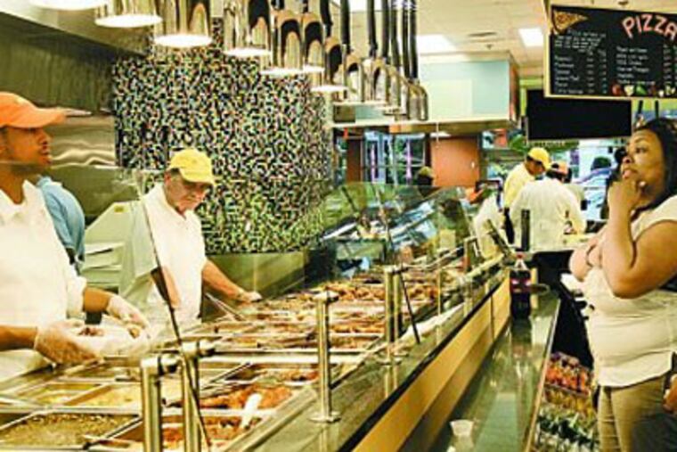 On opening day at Fresh Grocer in East Germantown, customer Leslie Williord considers her hot-food order. The developer received a grant to build supermarkets in underserved areas. (Bonnie Weller / Staff Photographer)