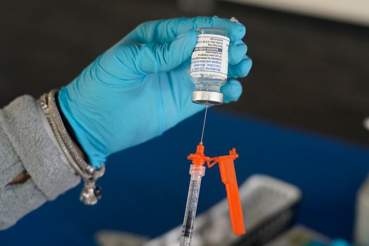 A Jackson-Hinds Comprehensive Health Center nurse loads a syringe with a Moderna COVID-19 booster vaccine at an inoculation station next to Jackson State University in Jackson, Miss., Friday, Nov. 18, 2022.