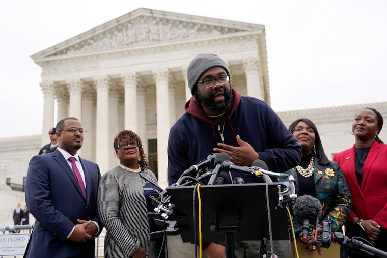 Evan Milligan, center, plaintiff in Merrill v. Milligan, an Alabama redistricting case, speaks with members of the press following oral arguments outside the Supreme Court on Capitol Hill in Washington, Oct. 4, 2022. Standing behind Milligan are Milligan's counsel Deuel Ross, from left, Letetia Jackson, Rep. Terri Sewell, D-Ala., and Janai Nelson, President and Director-Counsel of the NAACP Legal Defense Fund.