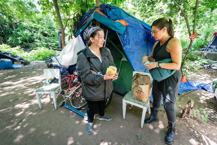 Draya LaMacchia (left) talks with homeless advocate and Villanova faculty member Stephanie Sena at a homeless encampment in Norristown.