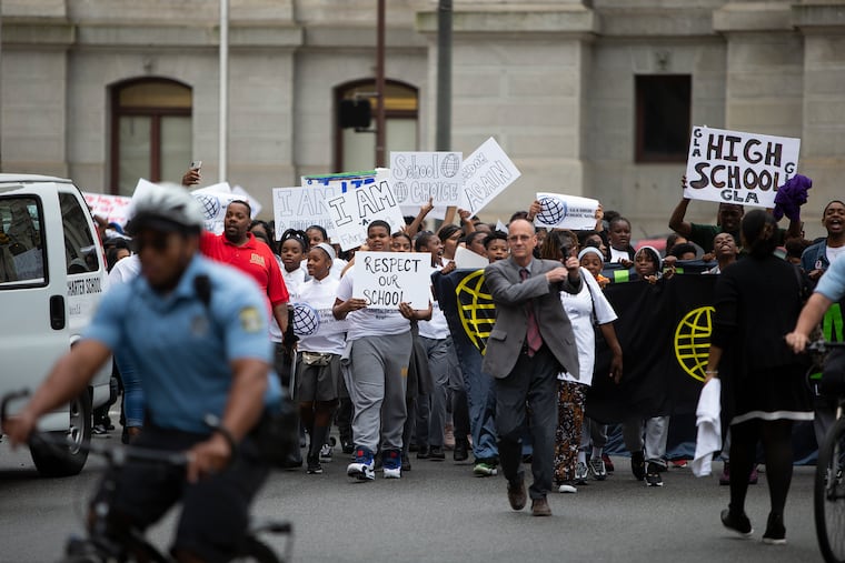 Students and supporters of Global Leadership Academy Charter School march down Broad Street on May 23, asking the Board of Education to approve its request to add a high school. The school's leader is among those who say the school district treats black-led schools unfairly.