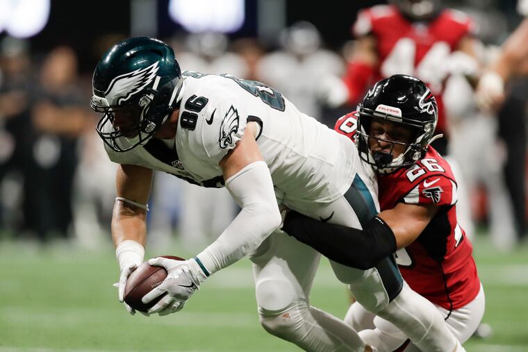 Eagles tight end Zach Ertz reaches for the first down line late in the fourth quarter against Falcons cornerback Isaiah Oliver on Sunday night.