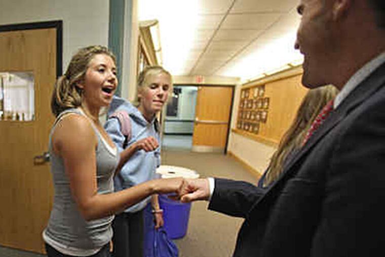 Abington Friends School student Marissa Cotroneo, 13, fist-bumps director Russell Shaw. With her is Sarah Arden. (David M Warren / Staff)