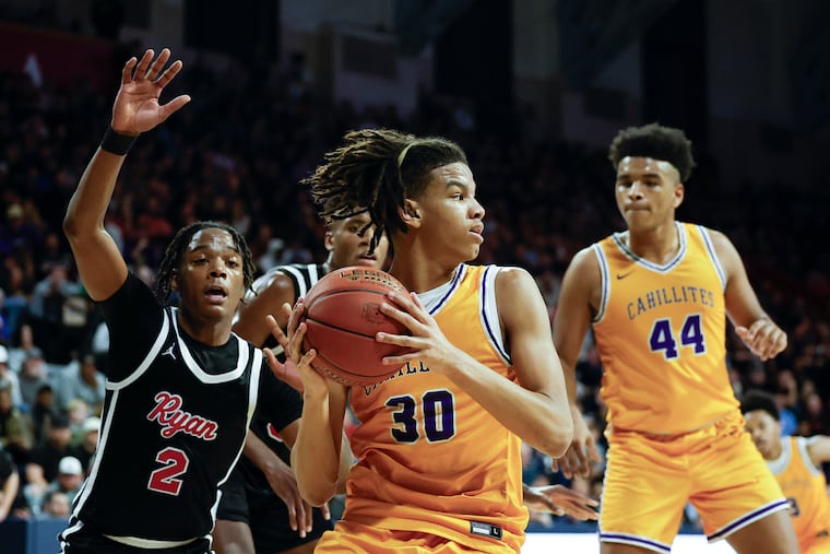 Roman Catholic’s Sammy Jackson holds the basketball as Archbishop Ryan’s Darren Williams tries to steal it during the Philadelphia Catholic League boys’ basketball championship game at the Palestra on Monday.