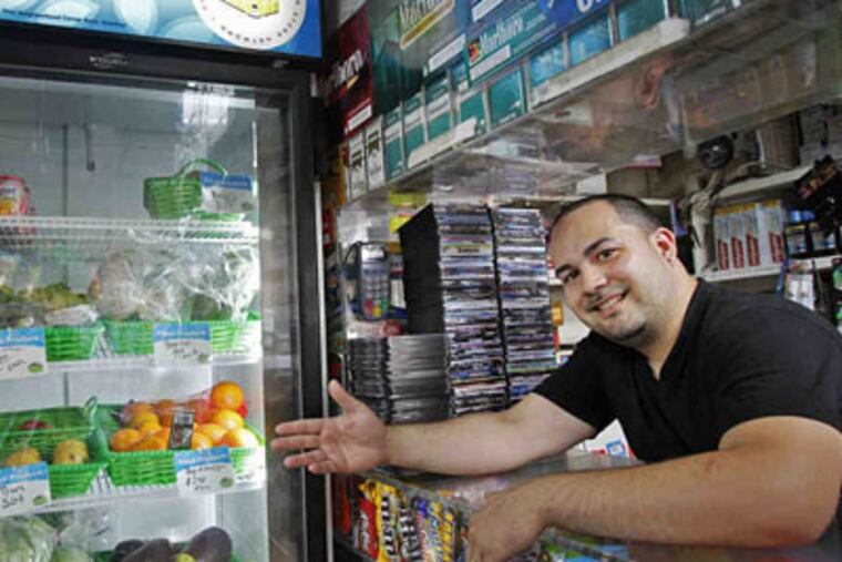 Jose Nunez of Robles Grocery recently qualified for a free refrigerator that allows him to sell yogurt, fruit salad and other perishables. (Alejandro A. Alvarez / Staff Photographer)